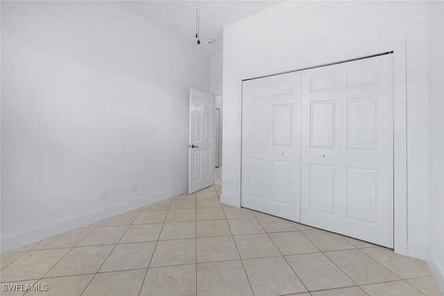 973 Summerfield Dr, Naples, FL 34120 - unfurnished bedroom with light tile patterned floors, a closet, and a high ceiling