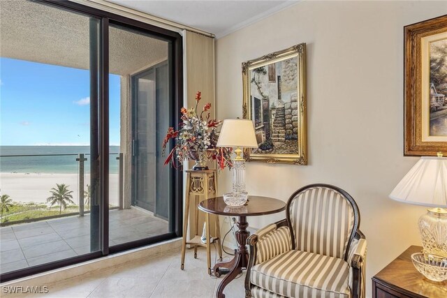 176 S Collier Blvd Unit 1107, Marco Island, FL 34145 - sitting room with view of water and beach, tile patterned flooring, and ornamental molding