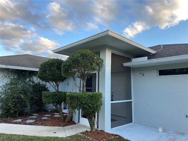 914 Avery St E, Lehigh Acres, FL 33974 - doorway to property with stucco siding and roof with shingles