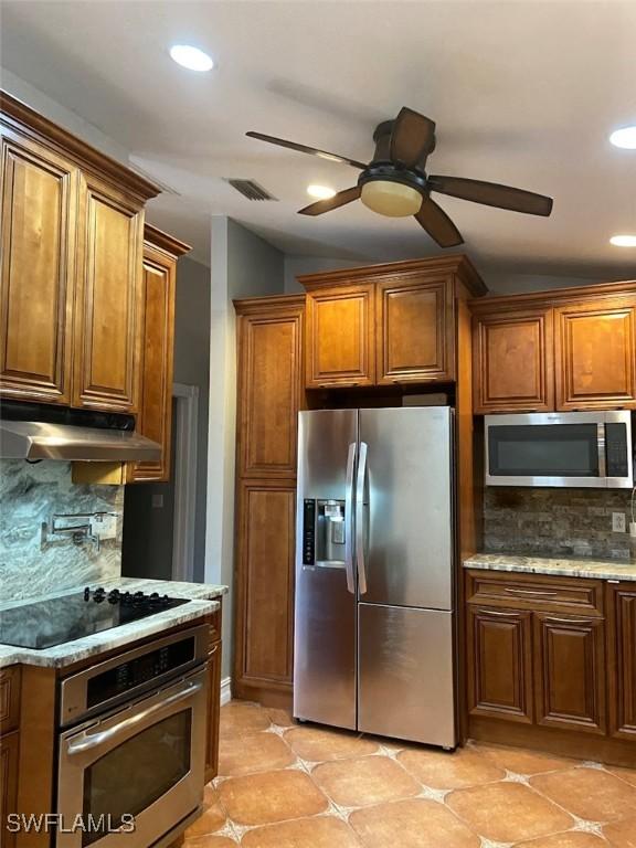 914 Avery St E, Lehigh Acres, FL 33974 - kitchen featuring stainless steel appliances, under cabinet range hood, recessed lighting, brown cabinetry, and decorative backsplash