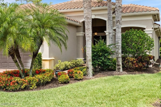 3051 Hudson Ter, Naples, FL 34119 - view of side of home featuring an attached garage, stucco siding, a lawn, and a tile roof