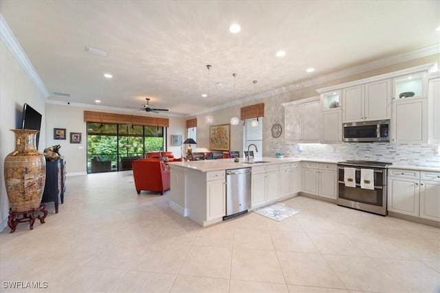 3051 Hudson Ter, Naples, FL 34119 - kitchen featuring appliances with stainless steel finishes, crown molding, open floor plan, ceiling fan, and a peninsula