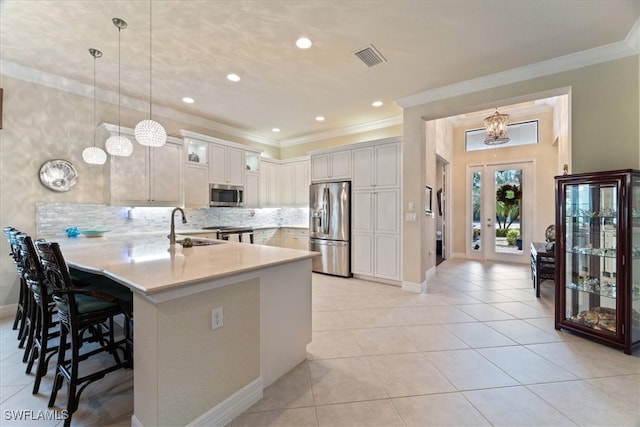 3051 Hudson Ter, Naples, FL 34119 - kitchen featuring appliances with stainless steel finishes, a peninsula, crown molding, a kitchen bar, and light countertops