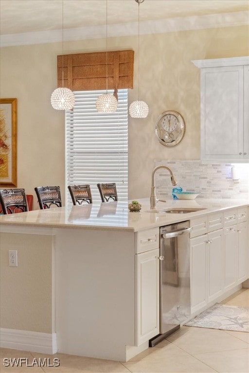 3051 Hudson Ter, Naples, FL 34119 - kitchen featuring stainless steel dishwasher, light countertops, white cabinets, light tile patterned flooring, and crown molding