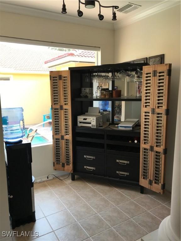 11491 Axis Deer Ln, Fort Myers, FL 33966 - bar area with tile patterned flooring and ornamental molding