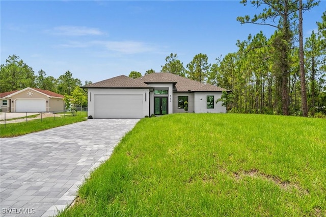4234 27th Ave NE, Naples, FL 34120 - prairie-style house featuring decorative driveway, a garage, a front lawn, french doors, and stucco siding