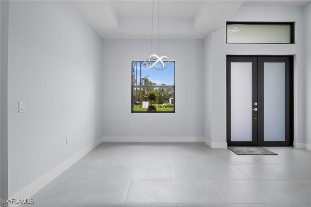 4234 27th Ave NE, Naples, FL 34120 - entryway with a chandelier, a tray ceiling, and tile patterned flooring