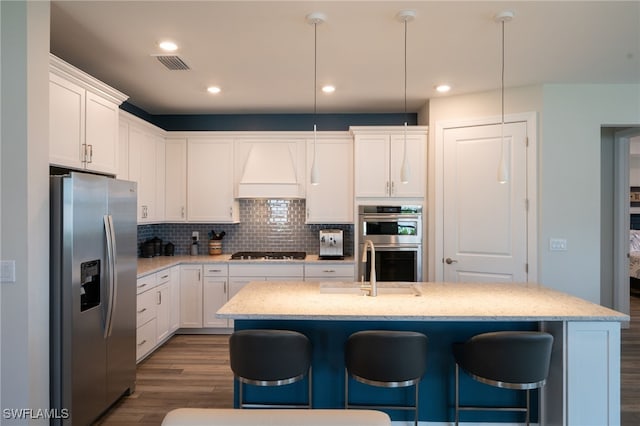 42243 Edgewater Dr, Punta Gorda, FL 33982 - kitchen with stainless steel appliances, custom range hood, dark wood-type flooring, a breakfast bar, and white cabinets