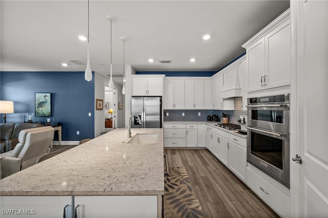42243 Edgewater Dr, Punta Gorda, FL 33982 - kitchen featuring appliances with stainless steel finishes, open floor plan, tasteful backsplash, dark wood-style floors, and white cabinets