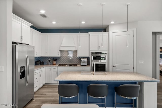 42243 Edgewater Dr, Punta Gorda, FL 33982 - kitchen featuring stainless steel appliances, light wood-style floors, a breakfast bar, white cabinetry, and recessed lighting