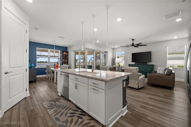 42243 Edgewater Dr, Punta Gorda, FL 33982 - kitchen with stainless steel dishwasher, white cabinetry, dark wood finished floors, a center island with sink, and light stone counters