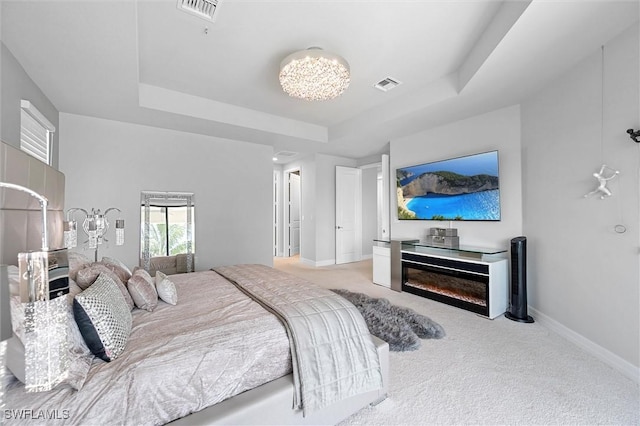 4692 Kensington Cir, Naples, FL 34119 - carpeted bedroom featuring a tray ceiling and a chandelier
