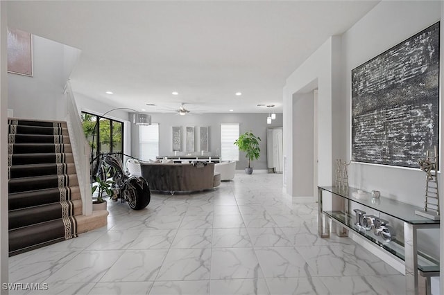 4692 Kensington Cir, Naples, FL 34119 - hallway with light marble finish flooring, stairway, recessed lighting, and plenty of natural light