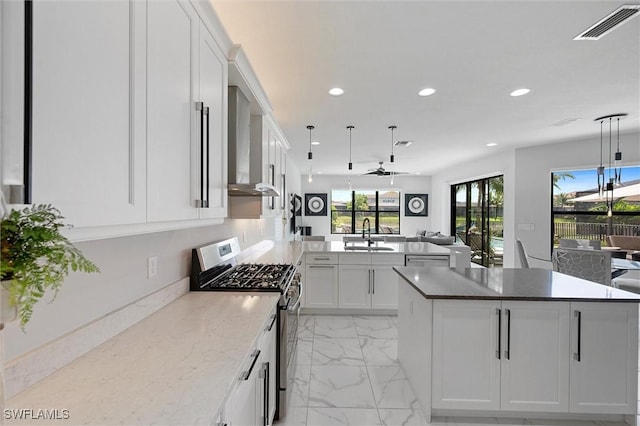 4692 Kensington Cir, Naples, FL 34119 - kitchen featuring appliances with stainless steel finishes, wall chimney exhaust hood, recessed lighting, open floor plan, and a center island