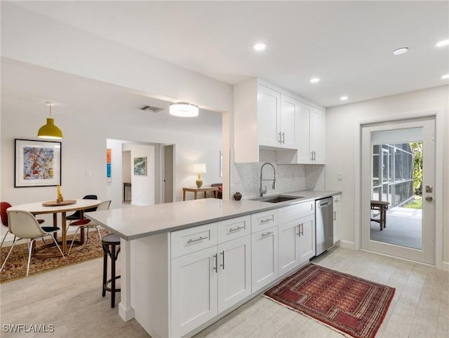 3704 Blue Heron Dr, Fort Myers, FL 33908 - kitchen featuring stainless steel dishwasher, light wood-type flooring, backsplash, white cabinets, and light countertops