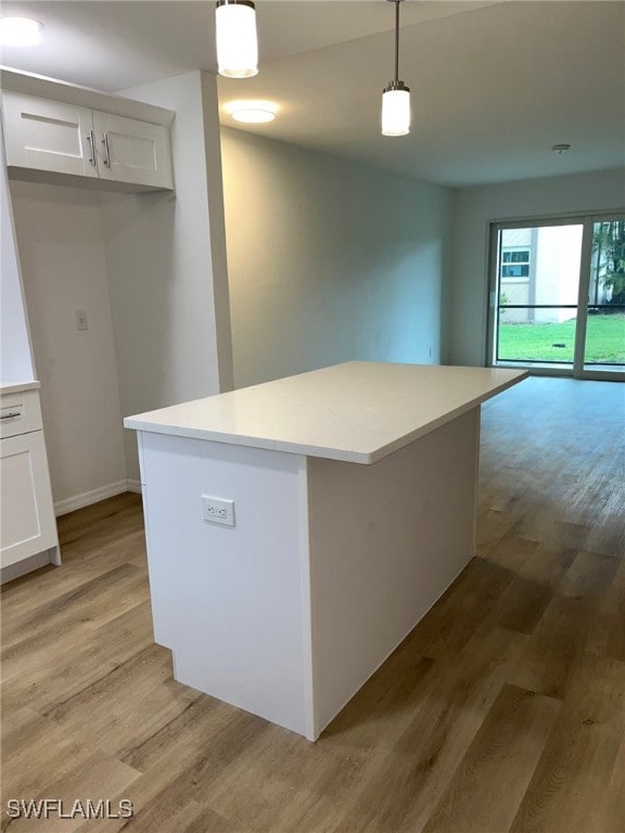 16881 Davis Rd Unit 713, Fort Myers, FL 33908 - kitchen featuring light wood-style floors, white cabinetry, light countertops, and hanging light fixtures