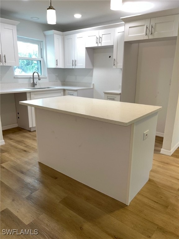 16881 Davis Rd Unit 713, Fort Myers, FL 33908 - kitchen with a kitchen island, white cabinets, light wood-style floors, decorative light fixtures, and recessed lighting