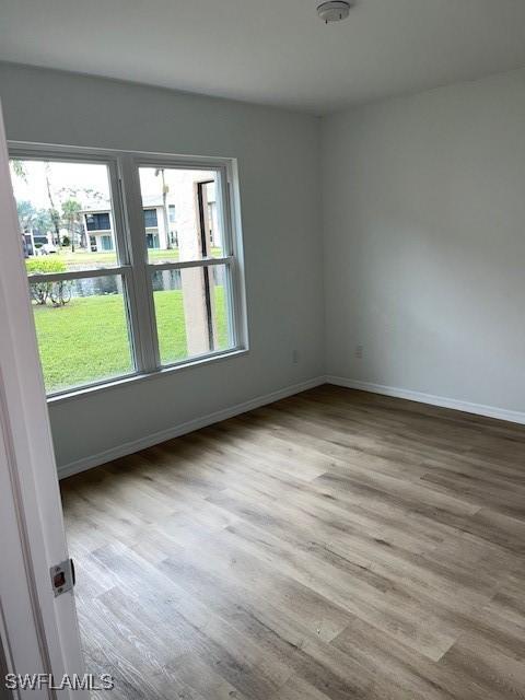 16881 Davis Rd Unit 713, Fort Myers, FL 33908 - empty room featuring plenty of natural light, wood finished floors, and a water view
