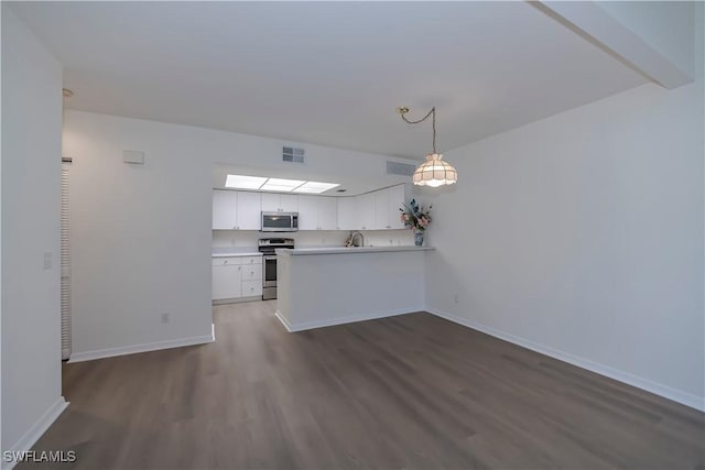 8441 N Haven Ln Unit B, Fort Myers, FL 33919 - kitchen featuring appliances with stainless steel finishes, dark wood-style floors, white cabinetry, light countertops, and decorative light fixtures