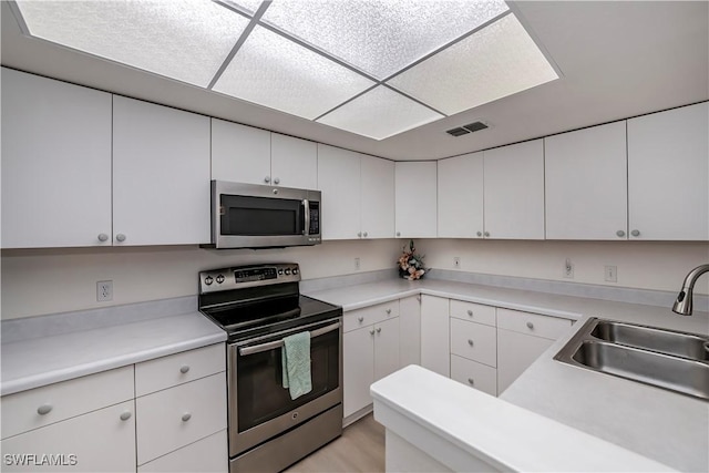 8441 N Haven Ln Unit B, Fort Myers, FL 33919 - kitchen featuring appliances with stainless steel finishes, white cabinetry, and light countertops