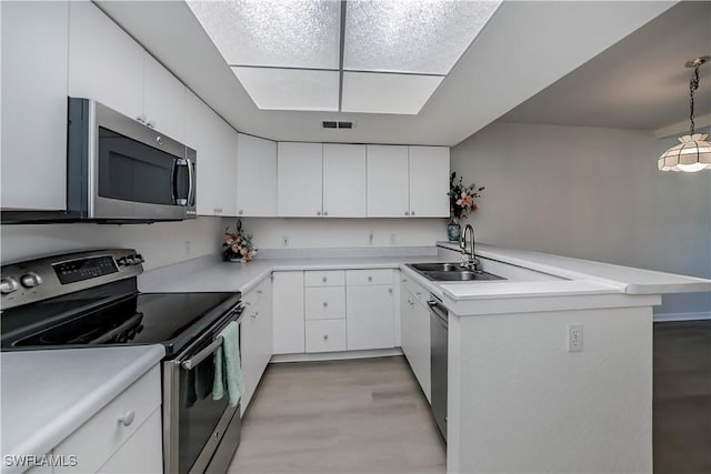 8441 N Haven Ln Unit B, Fort Myers, FL 33919 - kitchen featuring appliances with stainless steel finishes, light countertops, white cabinets, and a peninsula