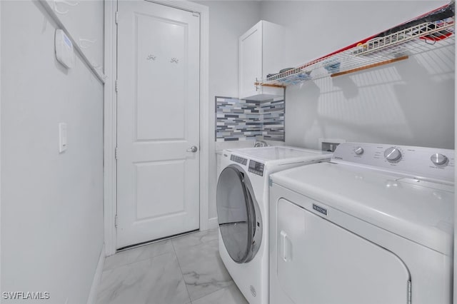 4447 26th Ave SE, Naples, FL 34117 - washroom featuring separate washer and dryer, cabinet space, and light marble finish flooring