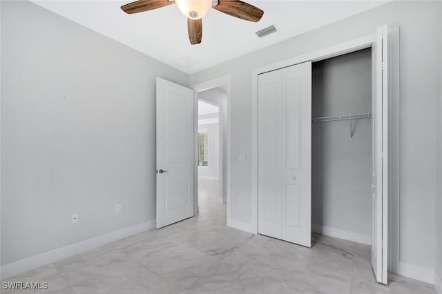 4447 26th Ave SE, Naples, FL 34117 - unfurnished bedroom featuring a closet, light marble finish floors, and ceiling fan