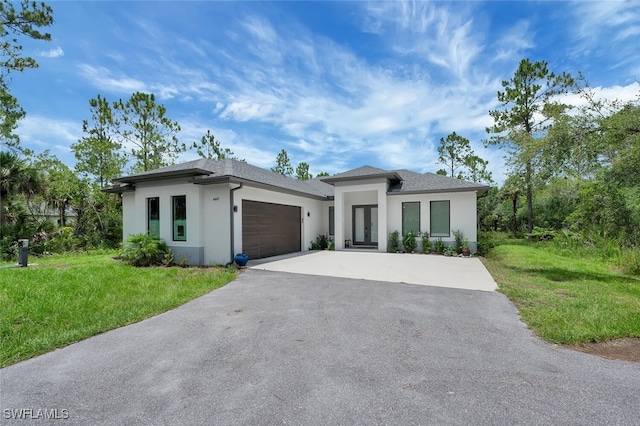 4447 26th Ave SE, Naples, FL 34117 - prairie-style home featuring driveway, stucco siding, an attached garage, and a front yard