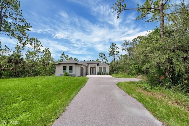 4447 26th Ave SE, Naples, FL 34117 - view of front facade featuring stucco siding, asphalt driveway, and a front yard