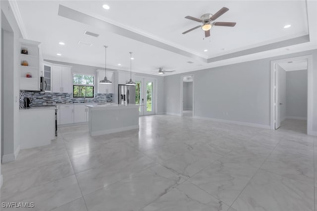 4447 26th Ave SE, Naples, FL 34117 - unfurnished living room featuring ceiling fan, recessed lighting, a tray ceiling, and crown molding