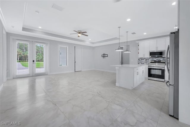 4447 26th Ave SE, Naples, FL 34117 - kitchen featuring appliances with stainless steel finishes, a raised ceiling, a ceiling fan, a center island, and open floor plan