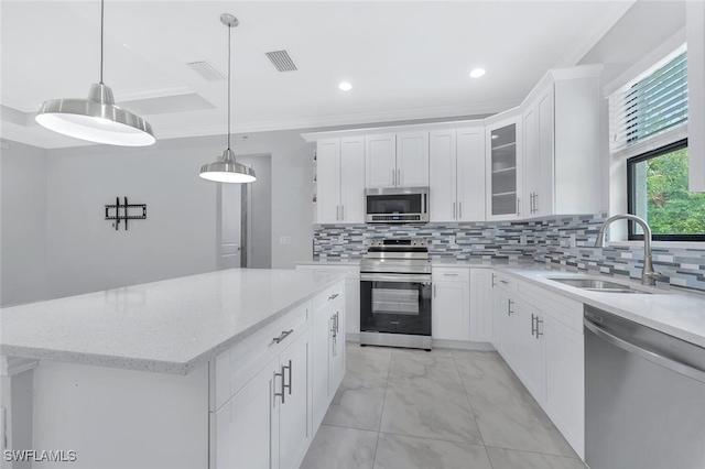 4447 26th Ave SE, Naples, FL 34117 - kitchen featuring appliances with stainless steel finishes, light marble finish flooring, white cabinetry, glass insert cabinets, and a kitchen island