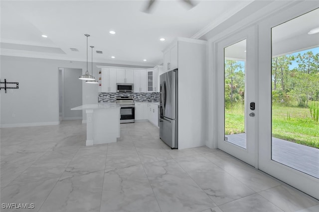 4447 26th Ave SE, Naples, FL 34117 - kitchen featuring stainless steel appliances, backsplash, a center island, light countertops, and ornamental molding