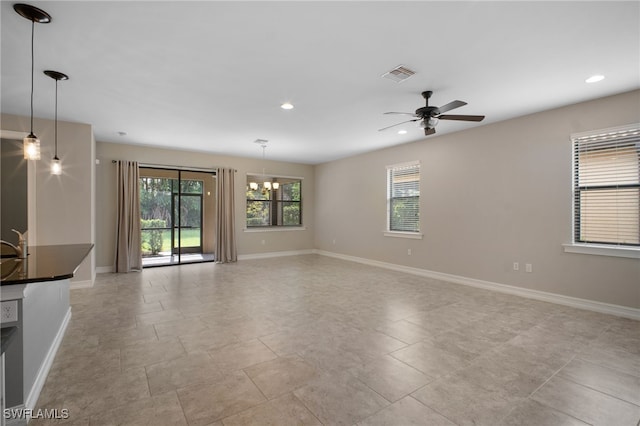 14332 Tuscany Pointe Cv, Naples, FL 34120 - unfurnished living room featuring a ceiling fan, recessed lighting, and a chandelier