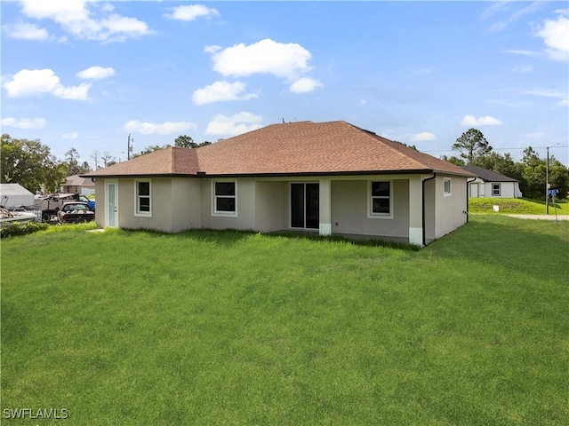 3801 14th St W, Lehigh Acres, FL 33971 - rear view of property with stucco siding, a yard, and roof with shingles