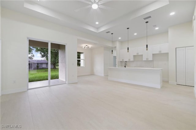3801 14th St W, Lehigh Acres, FL 33971 - unfurnished living room featuring a ceiling fan, recessed lighting, light wood finished floors, and a raised ceiling
