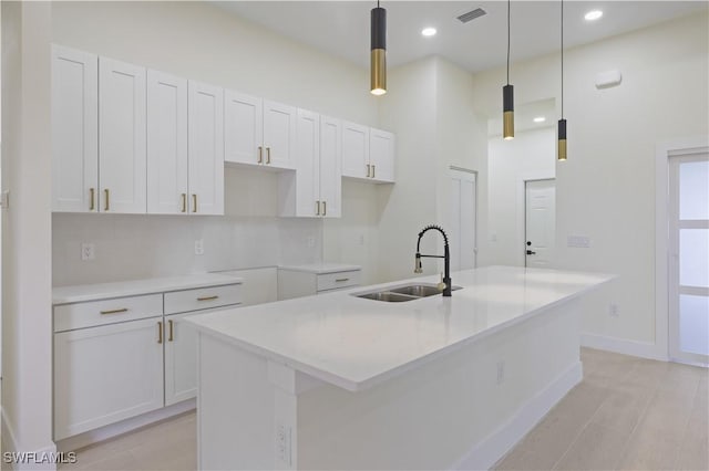 3801 14th St W, Lehigh Acres, FL 33971 - kitchen featuring a kitchen island with sink, white cabinets, recessed lighting, pendant lighting, and light countertops