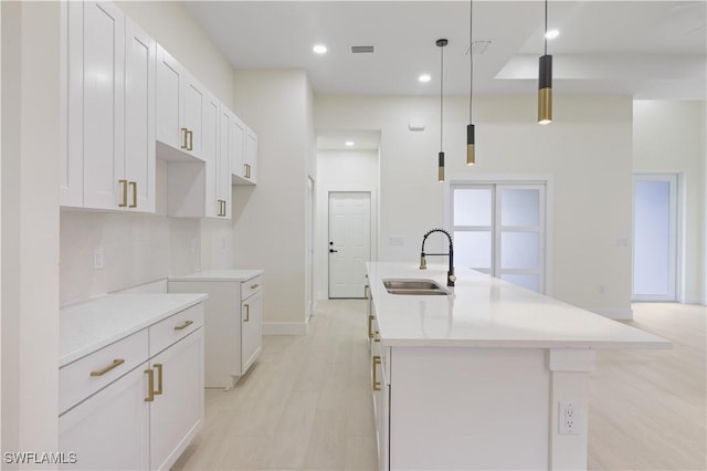 3801 14th St W, Lehigh Acres, FL 33971 - kitchen with a kitchen island with sink, recessed lighting, white cabinets, hanging light fixtures, and light countertops