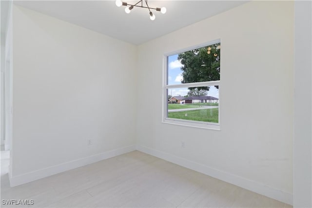 3801 14th St W, Lehigh Acres, FL 33971 - spare room featuring a chandelier and baseboards