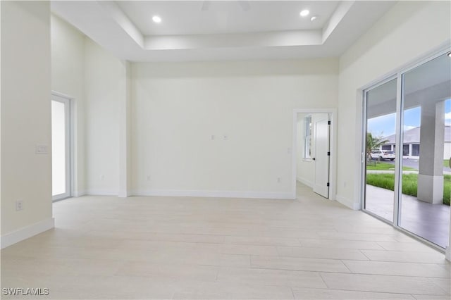 3801 14th St W, Lehigh Acres, FL 33971 - unfurnished room featuring plenty of natural light, light wood-type flooring, a raised ceiling, a towering ceiling, and recessed lighting
