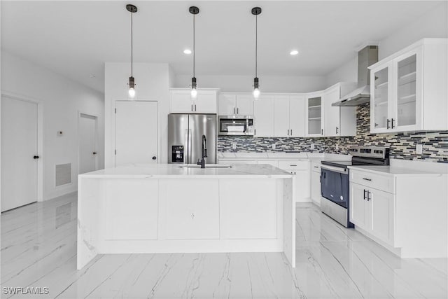 7071 Tide Cir, Labelle, FL 33935 - kitchen with appliances with stainless steel finishes, wall chimney range hood, light marble finish flooring, backsplash, and an island with sink