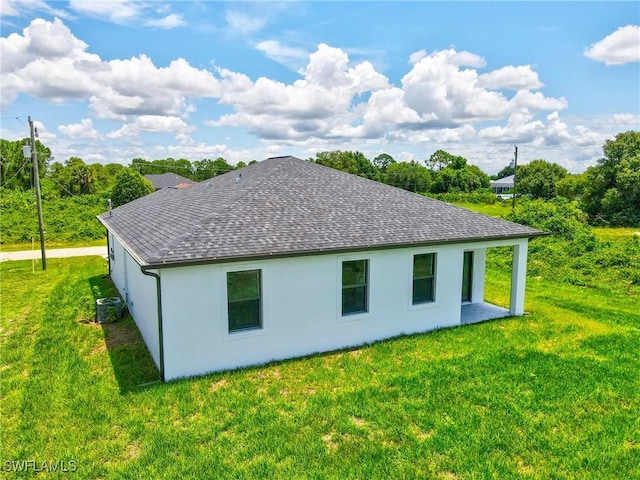 7071 Tide Cir, Labelle, FL 33935 - back of house with a shingled roof, a yard, and stucco siding