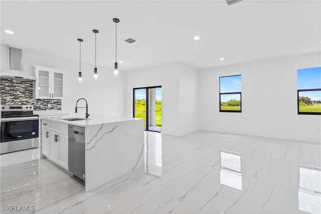 7071 Tide Cir, Labelle, FL 33935 - kitchen with stainless steel appliances, wall chimney range hood, light marble finish floors, open floor plan, and healthy amount of natural light