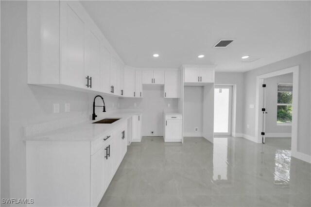 1132 Ravenswood St E, Lehigh Acres, FL 33974 - kitchen with white cabinets, recessed lighting, and light countertops