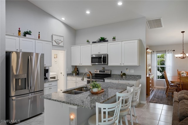 2804 NW 6th St, Cape Coral, FL 33993 - kitchen featuring stainless steel appliances, light tile patterned floors, high vaulted ceiling, white cabinetry, and light stone countertops