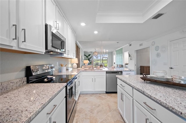 14040 Heritage Landing Blvd Unit 115, Punta Gorda, FL 33955 - kitchen with stainless steel appliances, a tray ceiling, recessed lighting, white cabinetry, and ornamental molding