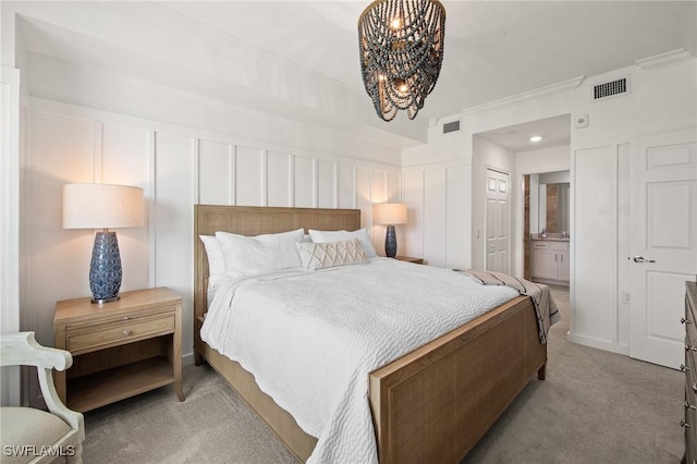 14040 Heritage Landing Blvd Unit 115, Punta Gorda, FL 33955 - bedroom featuring light carpet, a chandelier, a decorative wall, ornamental molding, and connected bathroom