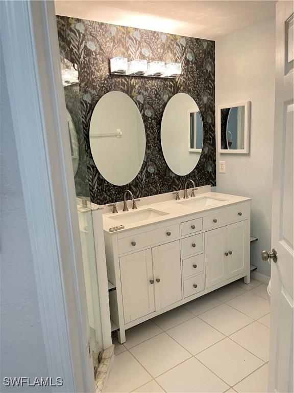 8241 Pacific Beach Dr, Fort Myers, FL 33966 - full bathroom with double vanity, wallpapered walls, and tile patterned flooring