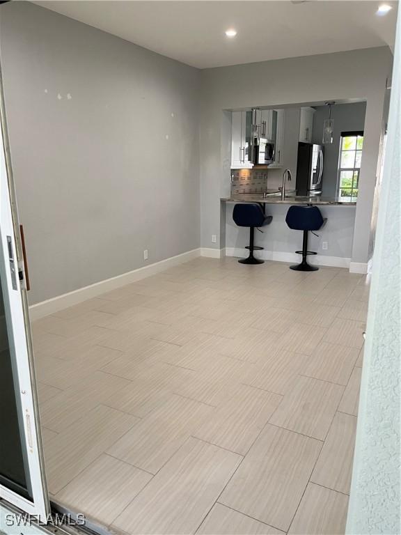 8241 Pacific Beach Dr, Fort Myers, FL 33966 - kitchen with stainless steel appliances, a breakfast bar, recessed lighting, and a peninsula