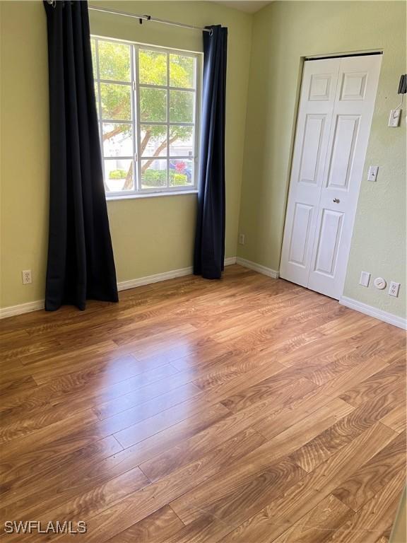 8241 Pacific Beach Dr, Fort Myers, FL 33966 - empty room with wood finished floors and baseboards
